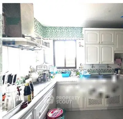 Charming kitchen with mosaic backsplash and ample natural light, perfect for culinary enthusiasts.