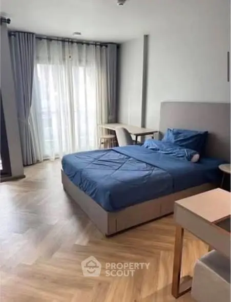 Spacious bedroom with modern decor and large window for natural light