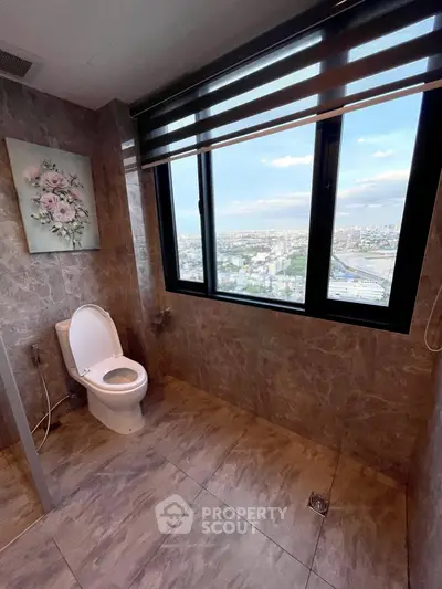 Luxurious bathroom with stunning city view through large window, elegant marble tiles, and modern fixtures.