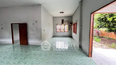Spacious open-plan living area with tiled flooring and garden view, perfect for family gatherings.