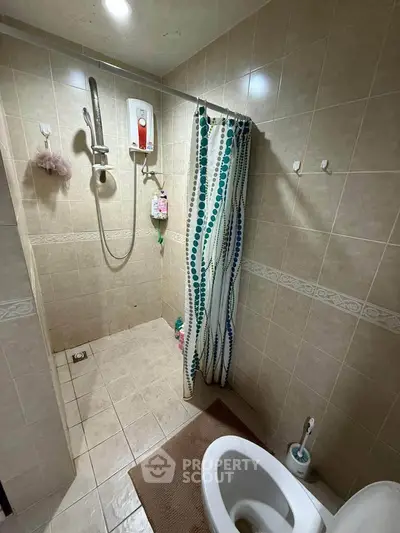Cozy bathroom with shower and tiled walls, perfect for a compact living space.
