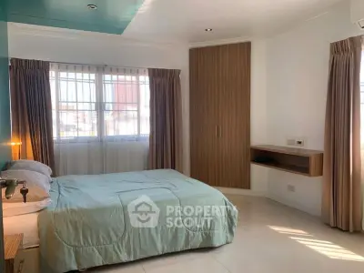 Spacious bedroom with natural light and modern furnishings in a stylish apartment.