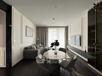Elegant living room with modern decor, large windows, and stylish furniture in a luxurious apartment.