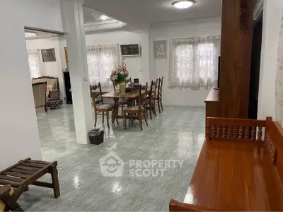 Spacious living and dining area with classic wooden furniture and ample natural light.