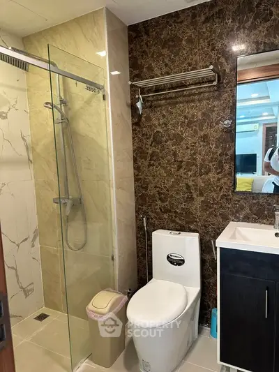 Modern bathroom with glass shower and marble accents in luxury apartment