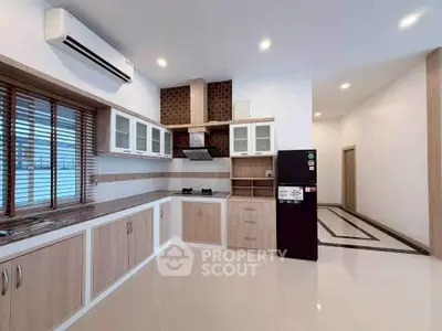 Spacious modern kitchen with sleek cabinetry and gas stove in a stylish open layout.