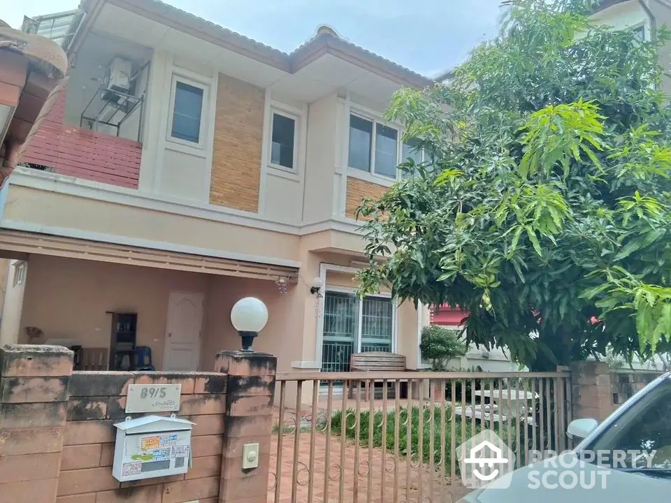 Charming two-story house with lush greenery and spacious front yard