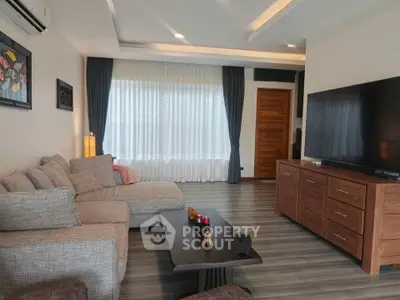 Spacious modern living room with large TV and stylish furniture
