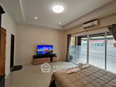 Spacious bedroom with modern decor and large windows for natural light.