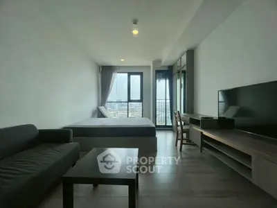 Modern studio apartment with city view, featuring sleek furniture and large windows for natural light.