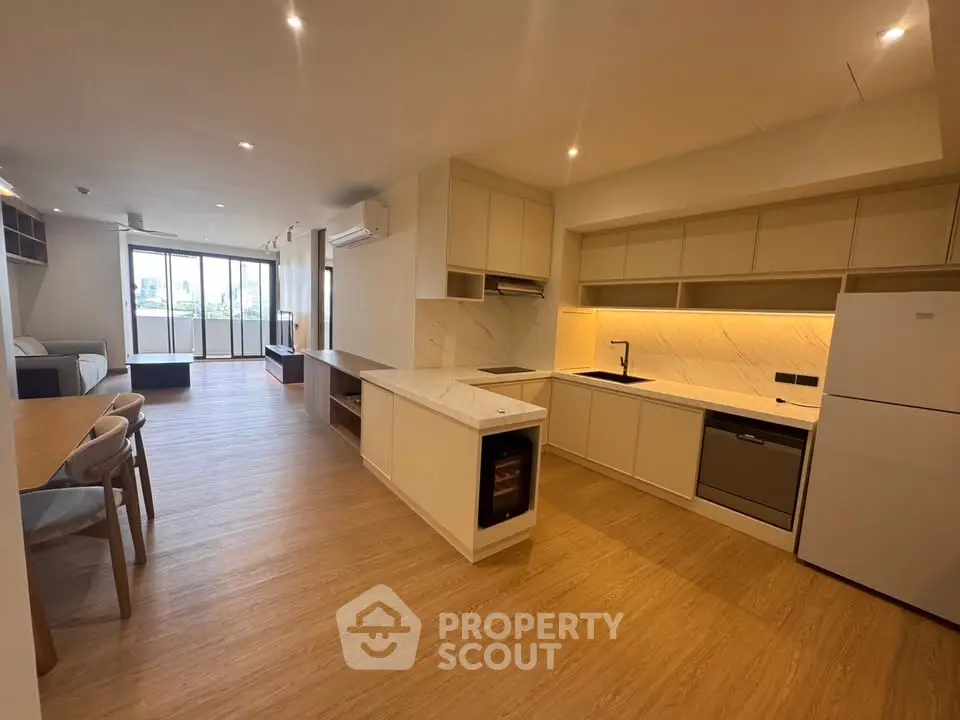 Spacious open-plan kitchen and living area with modern appliances and wooden flooring.