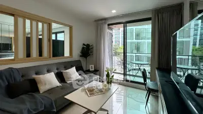 Modern living room with balcony view in a stylish apartment, featuring sleek furniture and abundant natural light.