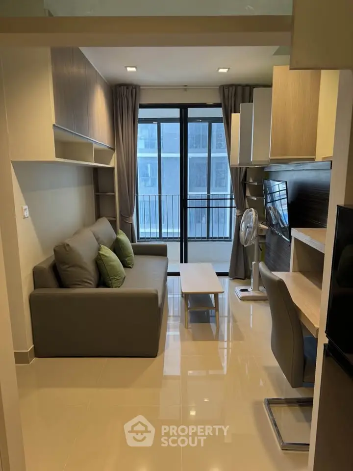Modern living room with sleek furniture and balcony view in a stylish apartment.