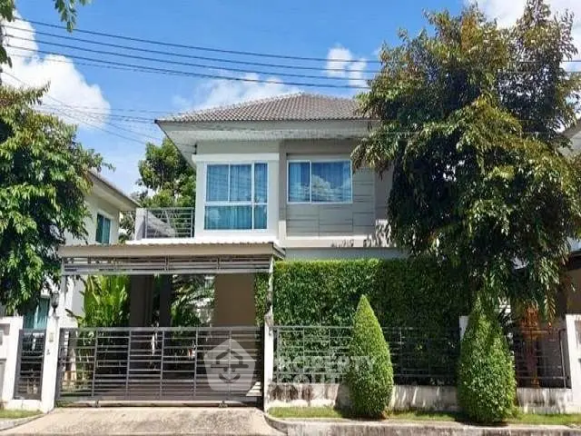 Charming two-story house with lush greenery and modern design in a serene neighborhood.