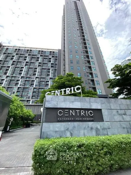 Modern high-rise condominium with lush greenery at Centric Ratchada-Huai Khwang.