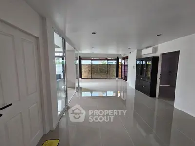Spacious modern living room with glossy tile flooring and large windows.