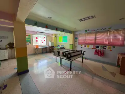 Spacious and colorful classroom with vibrant decor and ample natural light, perfect for creative learning.