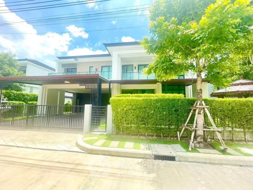 Modern two-story house with lush greenery and spacious driveway in a serene neighborhood.