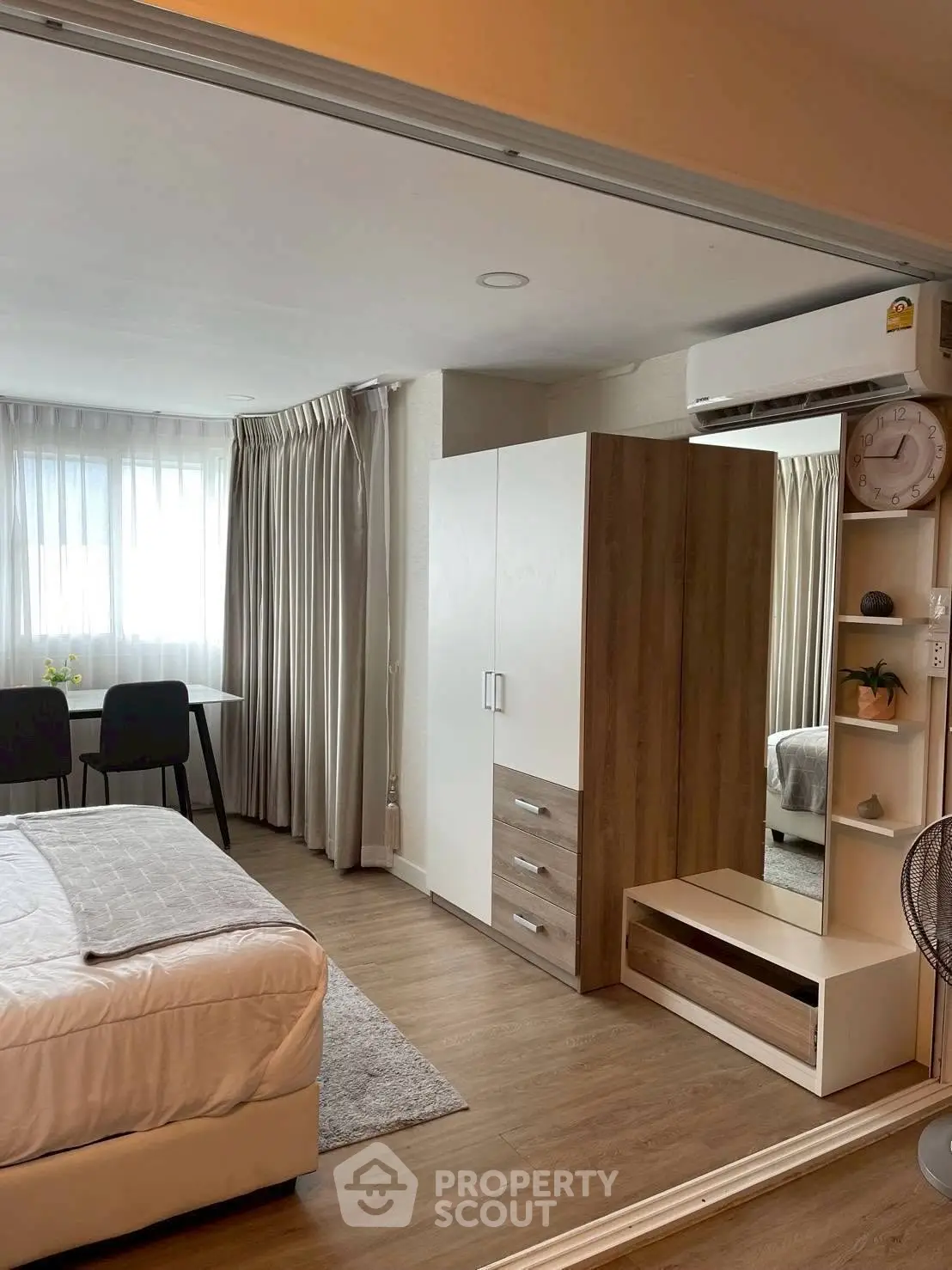 Modern bedroom with stylish furniture and natural light, featuring a cozy bed and elegant decor.