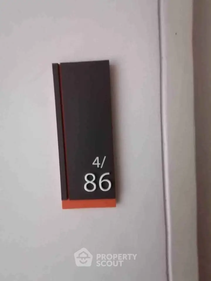 Modern apartment number sign on a wall, showcasing sleek design and contemporary style.