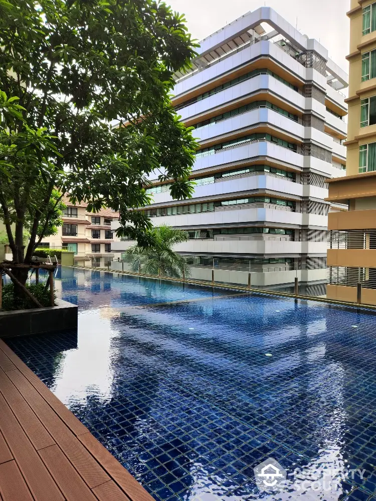 Luxurious modern apartment building with stunning pool view and lush greenery