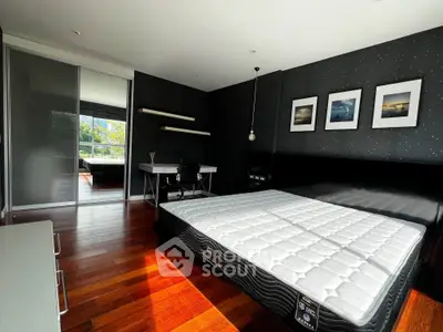 Spacious bedroom with modern decor, hardwood floors, and ample natural light.