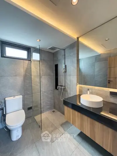 Modern bathroom with sleek design, featuring glass shower and stylish vanity.
