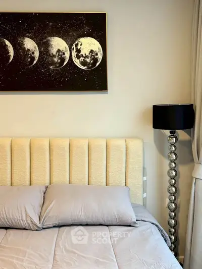Elegant bedroom with modern decor and moon phase artwork above plush bed.