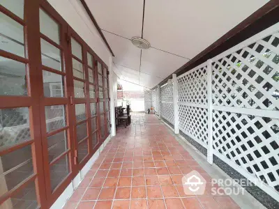 Charming covered patio with terracotta tiles and lattice fencing, perfect for outdoor relaxation.