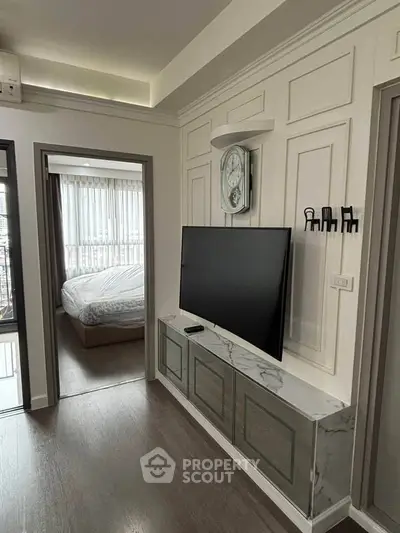 Modern apartment interior with sleek TV setup and cozy bedroom view