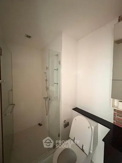 Modern bathroom with glass shower and sleek fixtures in contemporary apartment