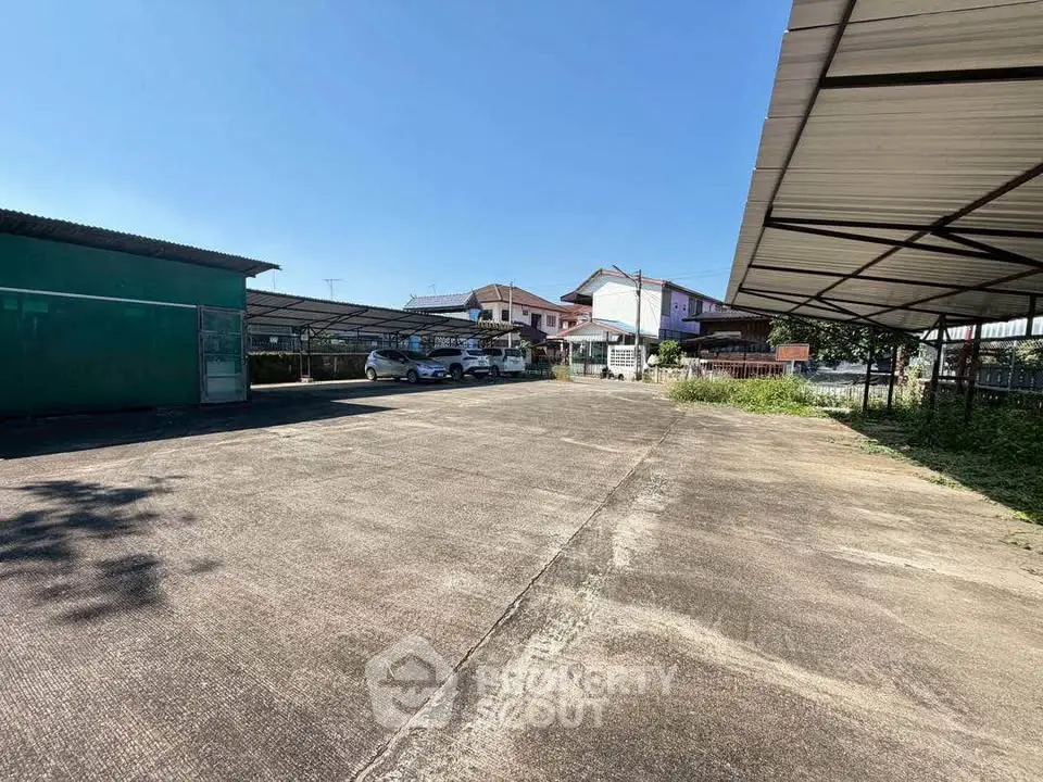 Spacious outdoor parking area with covered spaces in a residential neighborhood.
