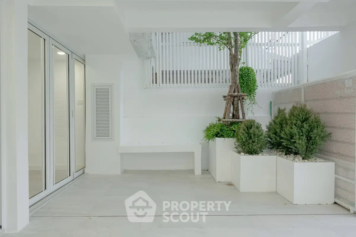 Modern minimalist outdoor space with greenery and sleek white design