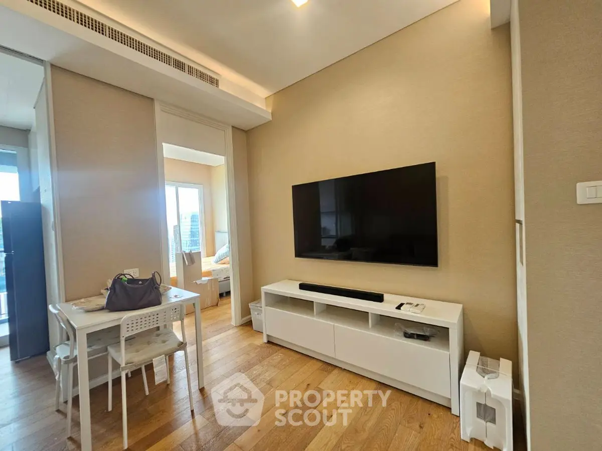 Modern living room with sleek TV setup and dining area in stylish apartment