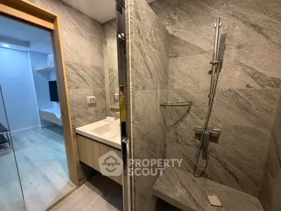 Modern bathroom with sleek shower and stylish vanity in contemporary apartment.