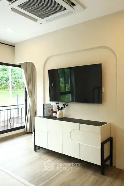 Modern living room with sleek TV setup and stylish console in bright interior.