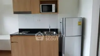 Compact kitchen with modern appliances and wooden cabinetry