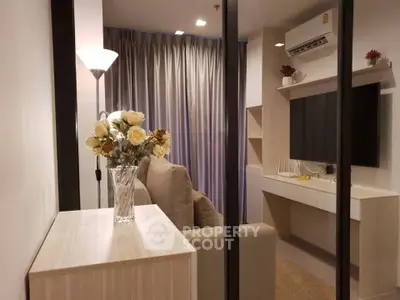 Modern living room with elegant decor and cozy ambiance, featuring a stylish sofa and wall-mounted TV.