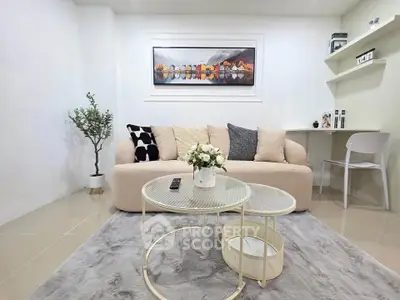 Modern living room with cozy beige sofa, stylish decor, and chic coffee table on plush rug.