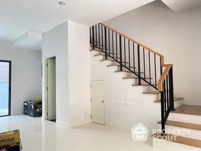 Modern interior with sleek staircase and glossy white flooring in a contemporary home.