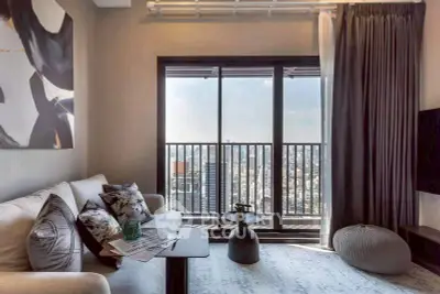 Stylish living room with city view balcony, modern decor and cozy seating.
