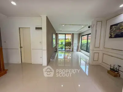 Spacious living room with glossy tile flooring and garden view, perfect for modern living.