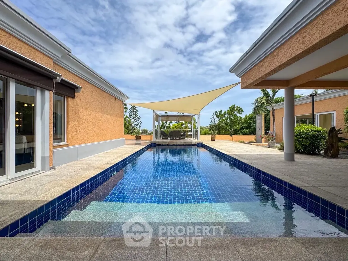 Luxurious villa with stunning pool and modern design under a clear blue sky.