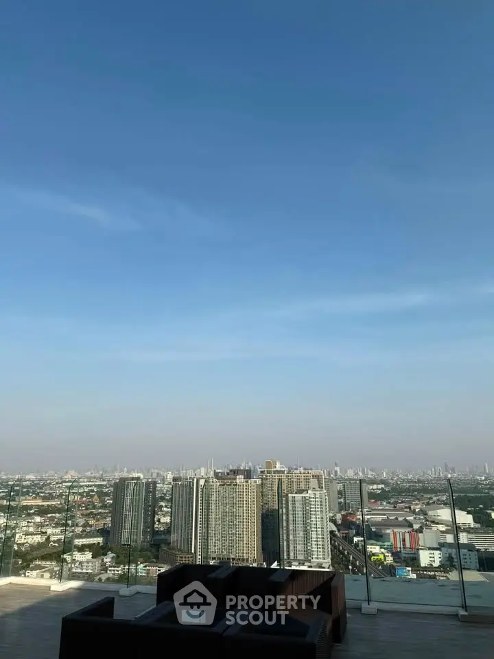 Stunning rooftop view of city skyline with modern outdoor seating area.