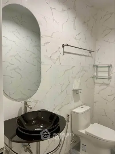 Modern bathroom with elegant black sink and marble walls