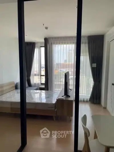 Modern bedroom with large windows and stylish decor in a contemporary apartment.
