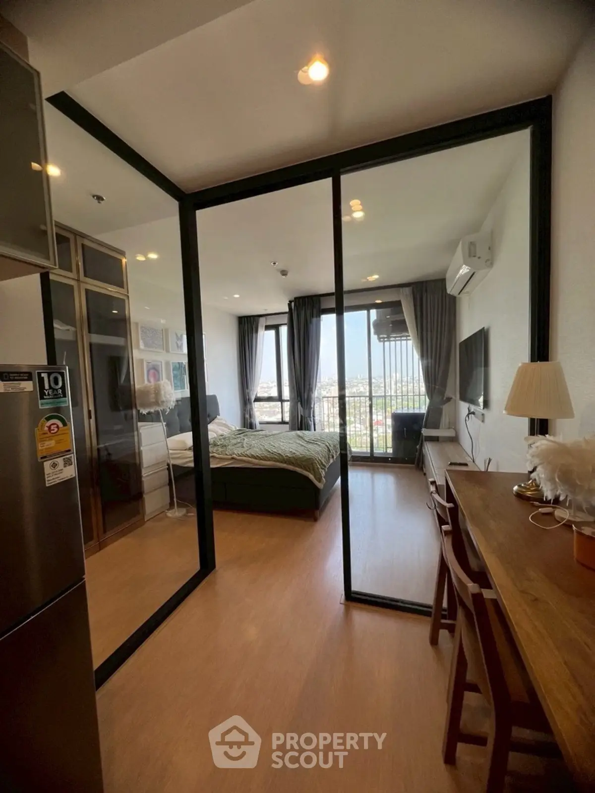 Modern studio apartment with glass partition and city view balcony