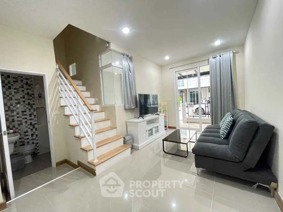 Modern living room with sleek staircase and balcony access