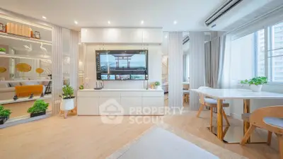 Modern living room with sleek design, large TV, and natural light from windows.