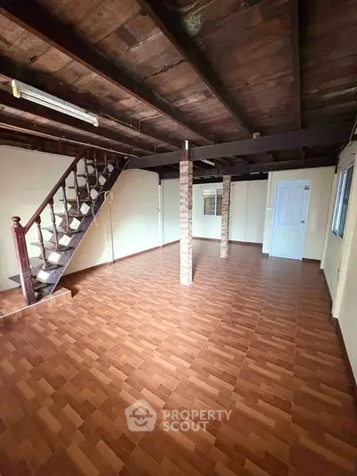 Spacious interior with wooden staircase and tiled flooring, ideal for customization.